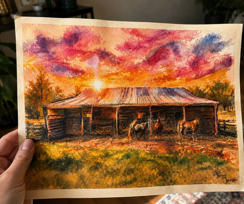 Watercolor painting of horses at a rustic barn at sunrise
