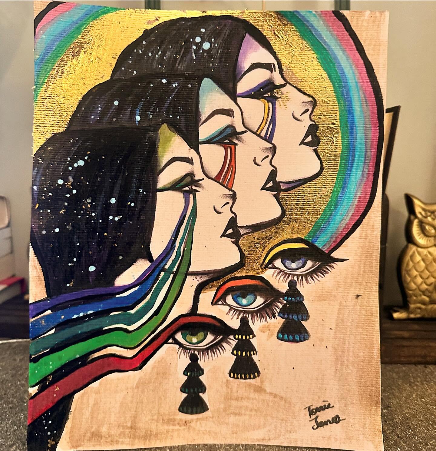 Rainbow Faces — original painting of three faces with rainbow hair and colorful eyes on gold, signed by Torrie Jones